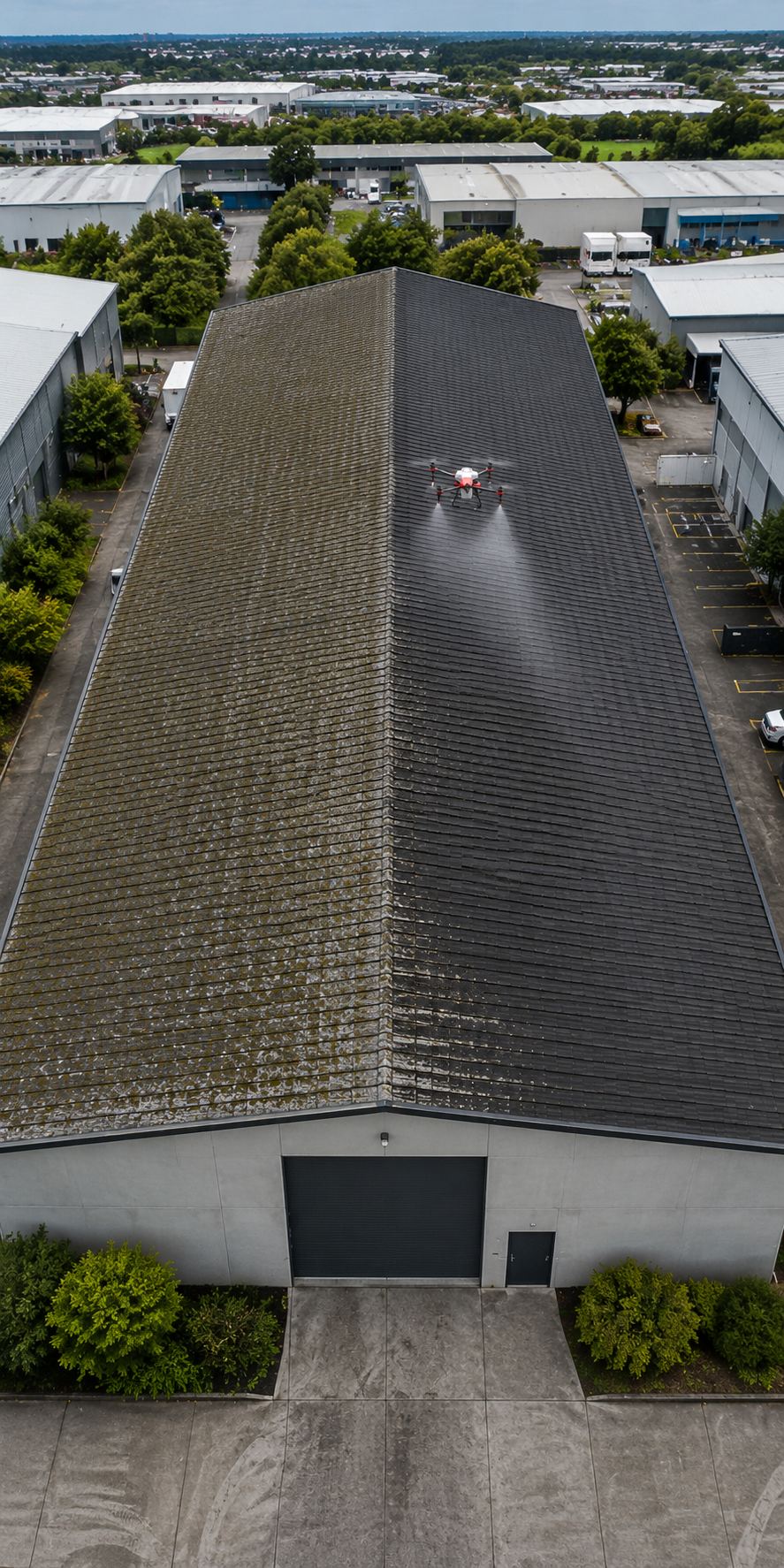 Wash drone soft-washing a long warehouse roof