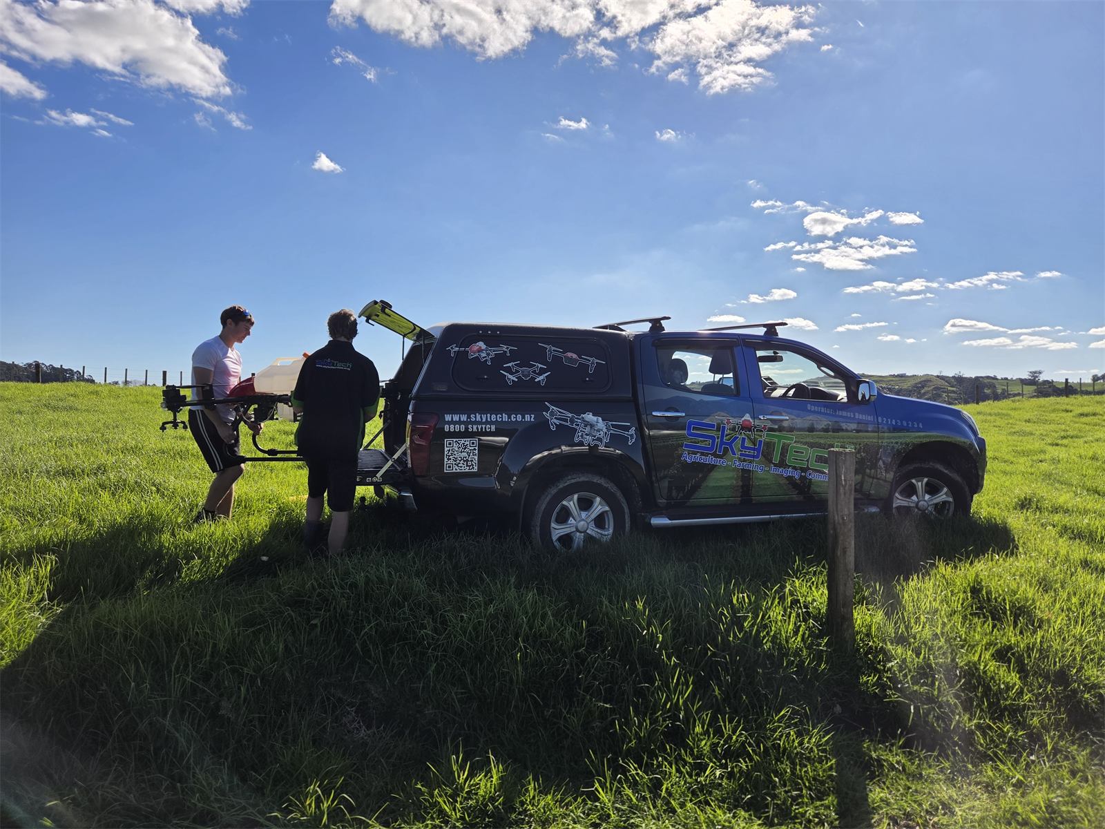 Loading the spray drone from the SkyTech ute in a paddock